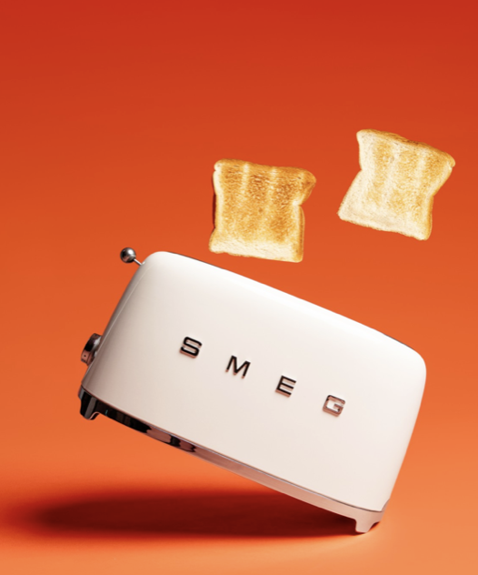 Torradeira SMEG branca com torradas saltando