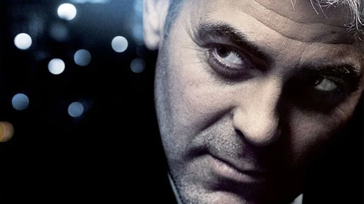 Close-up of intense man with piercing gaze against a blurred night lights background