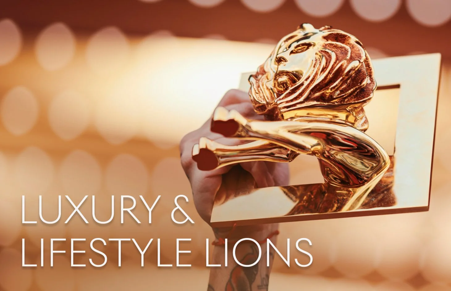 Golden luxury and lifestyle lion trophy held up against a blurred background.