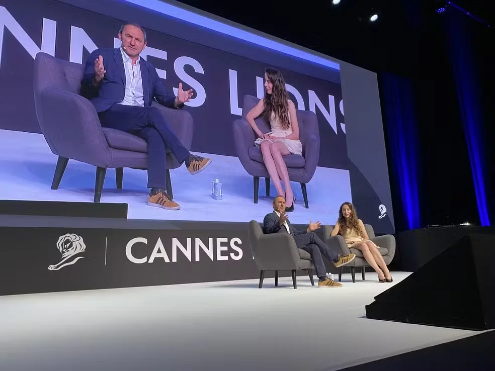 Panel discussion at Cannes Lions with two speakers on stage.