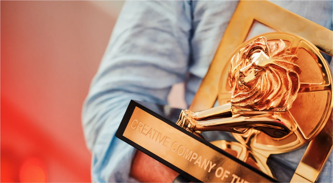 Person holding a golden lion trophy for Creative Company of the Year