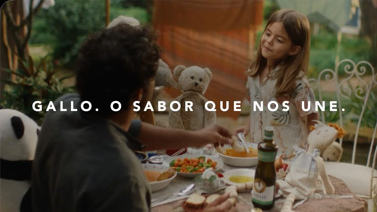 Family enjoying a meal together with Gallo products on the table, featuring a young girl and stuffed animals.