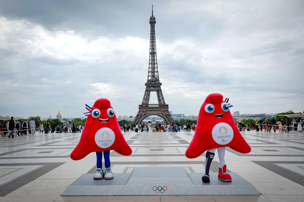 Paris 2024 Olympic mascots in front of Eiffel Tower