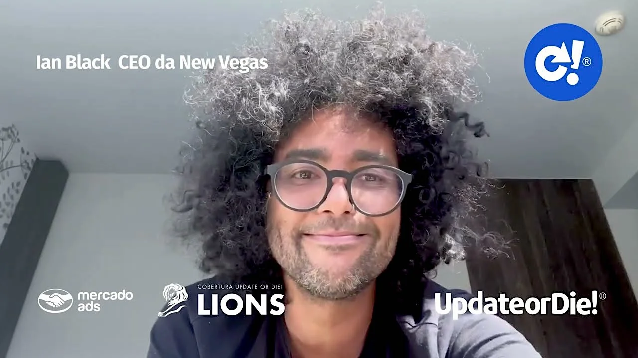 Man with curly hair and glasses smiling, with logos of Mercado Ads, Lions, and Update or Die in the background, text reads "Ian Black CEO da New Vegas".