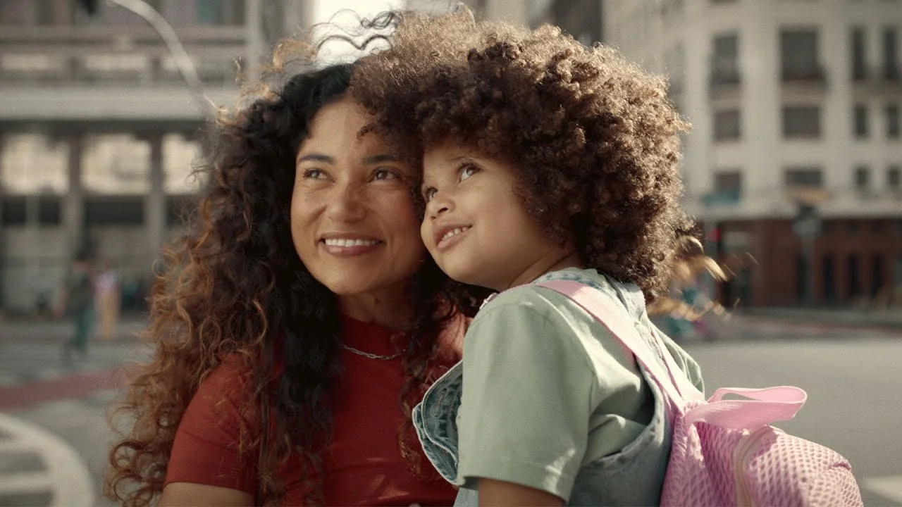 Mother and child smiling outdoors in the city.