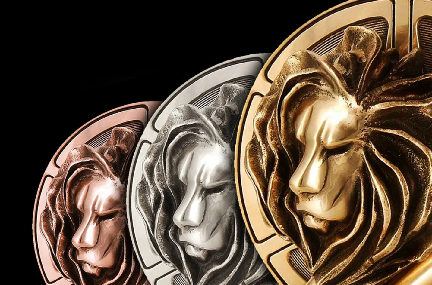 Bronze, silver, and gold lion head medallions on a black background.