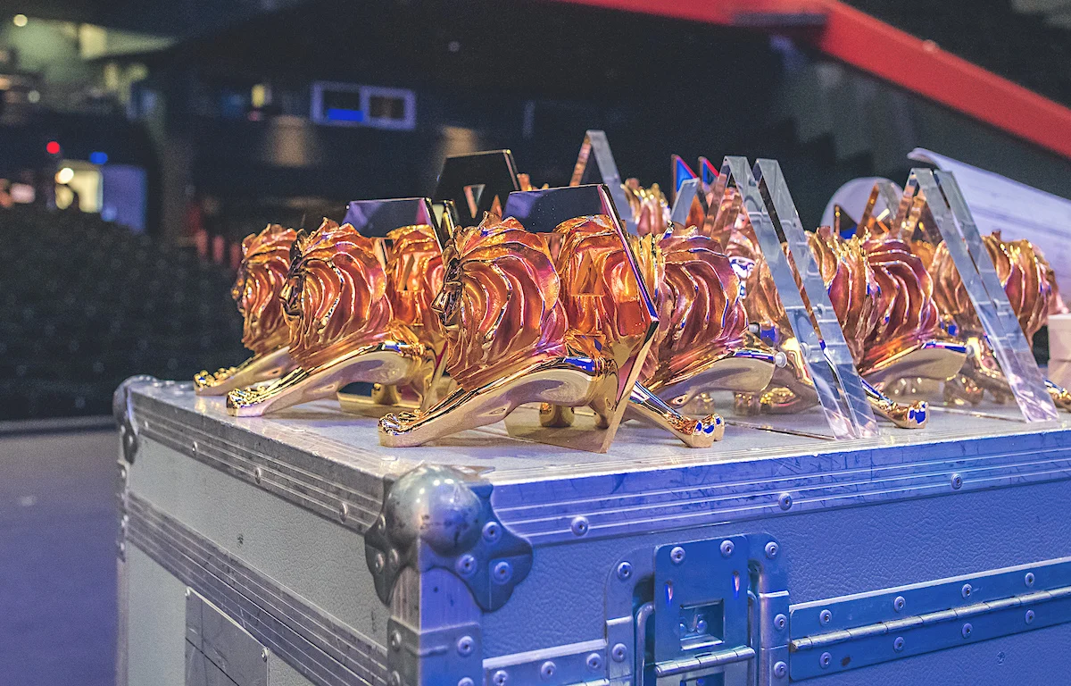 Golden lion trophies displayed on a table at an awards event.