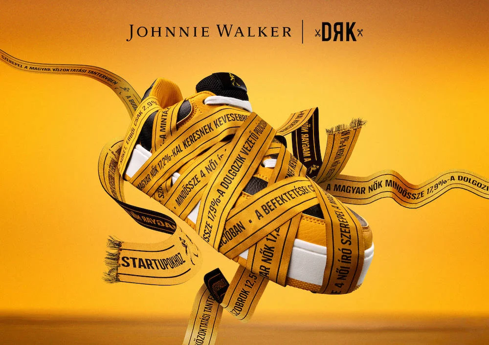 The Uncomfortable Unboxing. Yellow sneaker wrapped in yellow tape with Hungarian text, Johnnie Walker and DRK collaboration.