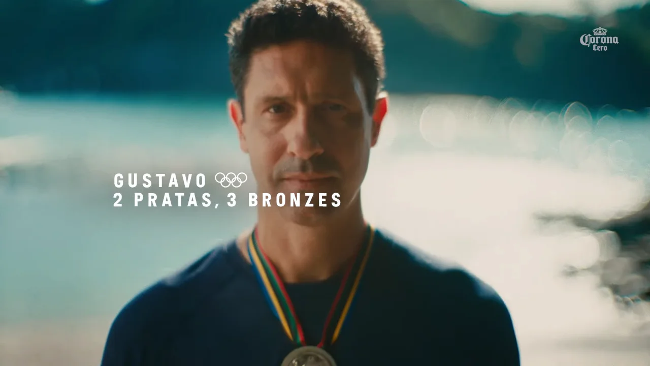 Olympic medalist with two silver and three bronze medals wearing a medal and standing near water.