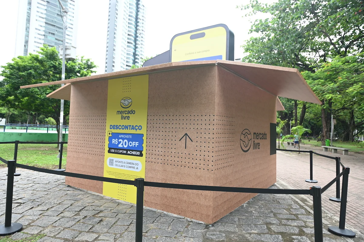 Mercado Livre promotional booth in a park offering a discount of R$20 with a coupon code.