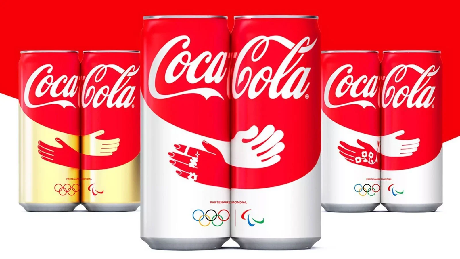 Coca-Cola cans with Olympic and Paralympic partnership design featuring hugging hands.