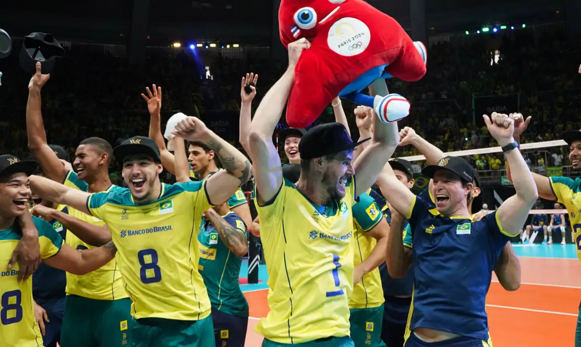 Brazilian men's volleyball team celebrating victory with mascot at Paris 2024 Olympic qualifiers.