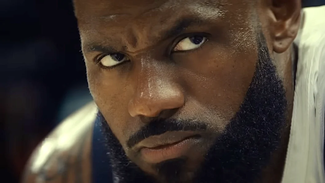 Close-up of a focused male basketball player with a strong beard and intense expression, showcasing determination and concentration during a game.