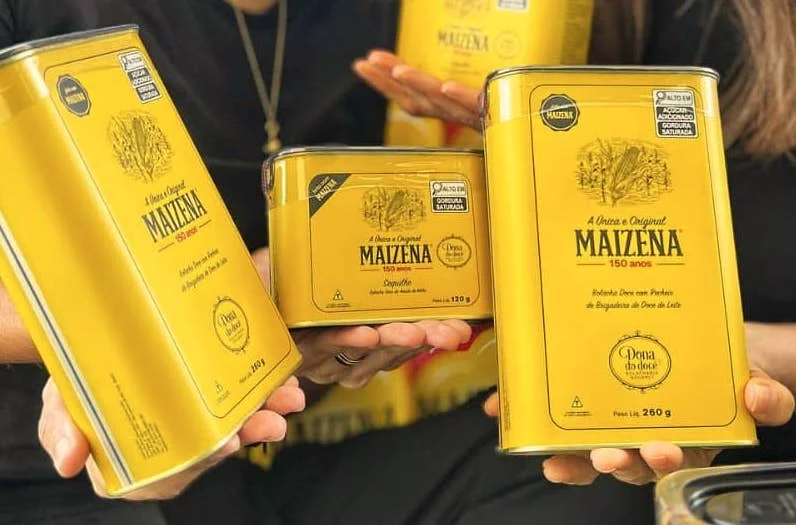 Variety of Maizena cornstarch products displayed in yellow packaging, featuring different sizes including 120g and 260g cans, highlighting the brand's 150-year heritage.