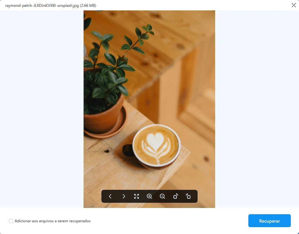 A beautifully crafted latte art with a heart design, placed on a wooden table next to a potted plant. The warm tones of the coffee and the natural wood create a cozy atmosphere.