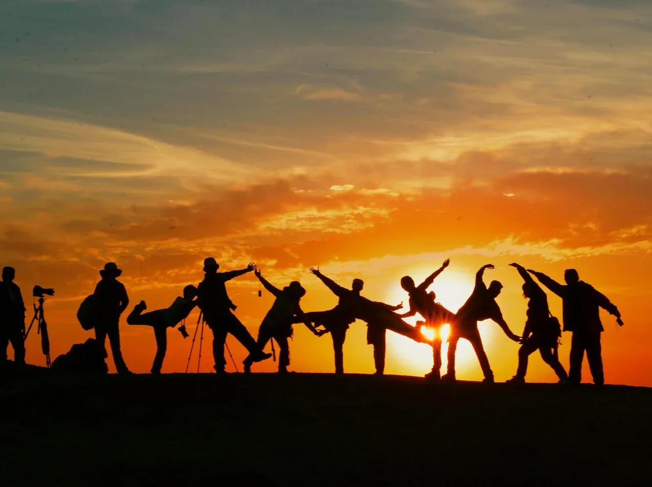 Silhuetas de pessoas brincando ao pôr do sol