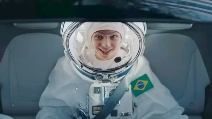 Astronauta brasileiro sorrindo dentro de um carro