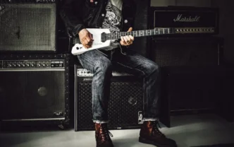 Guitarrista tocando frente a amplificadores Marshall.