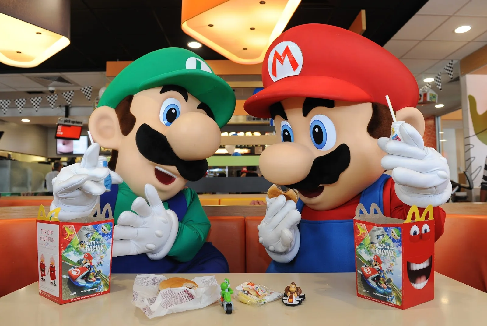 Personagens fantasiados comendo no McDonald's com brinquedos.