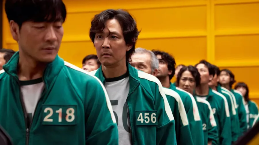 Pessoas com uniformes verdes alinhadas em fila.