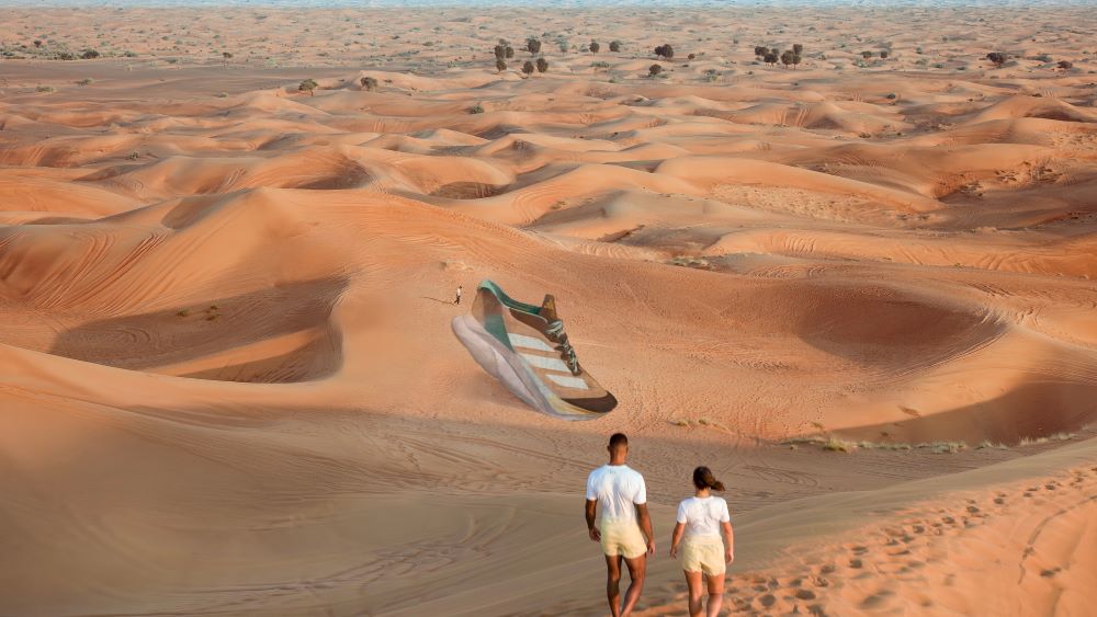 Casal caminha por dunas de areia no deserto.