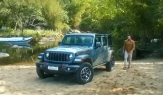 Jeep na praia com homem ao lado