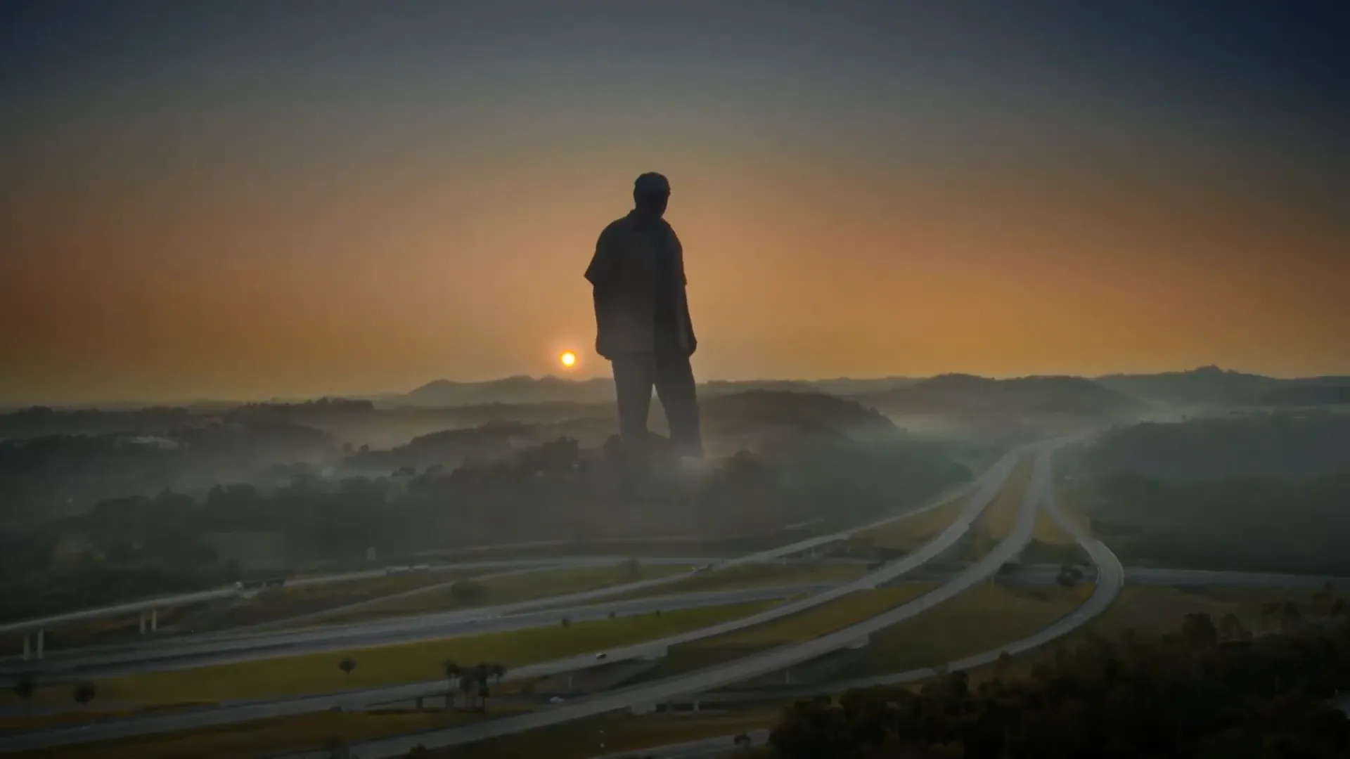 Estátua gigante ao pôr do sol sobre estrada