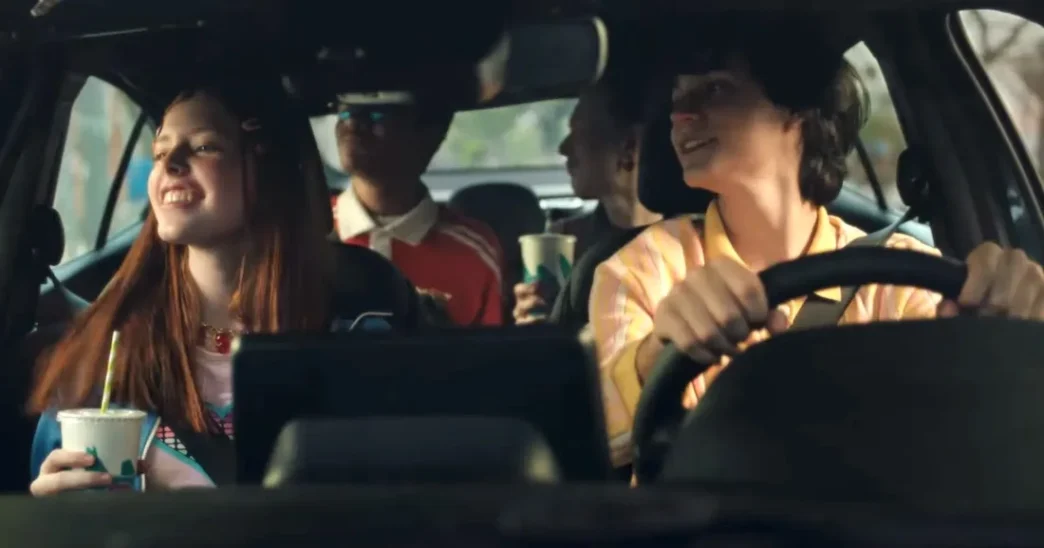 Amigos felizes dirigindo e tomando bebidas no carro.