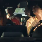 Amigos felizes dirigindo e tomando bebidas no carro.