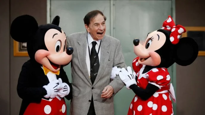 Homem sorrindo entre Mickey e Minnie Mouse.