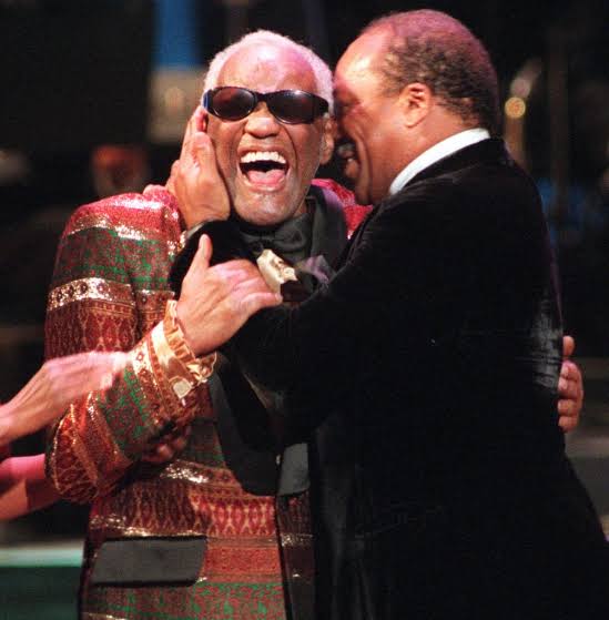 Dois homens sorrindo e se abraçando em um evento.