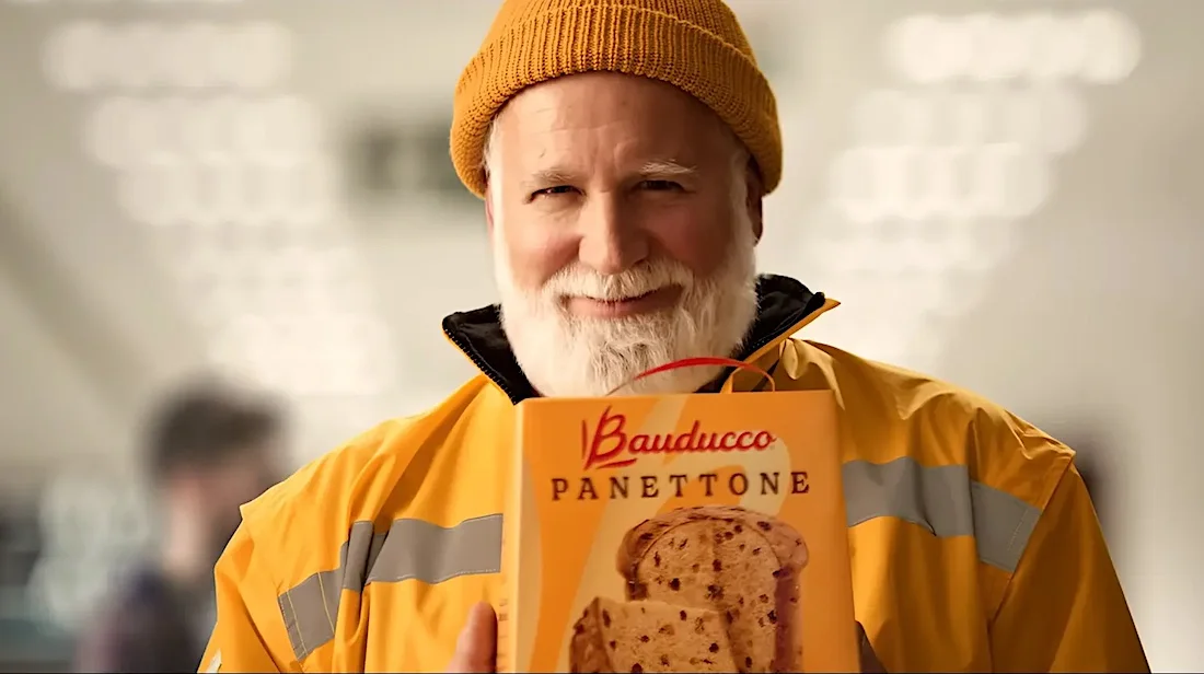 Homem segurando panetone Bauducco em embalagem.