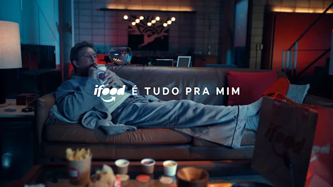 Pessoa relaxando no sofá com entrega iFood.