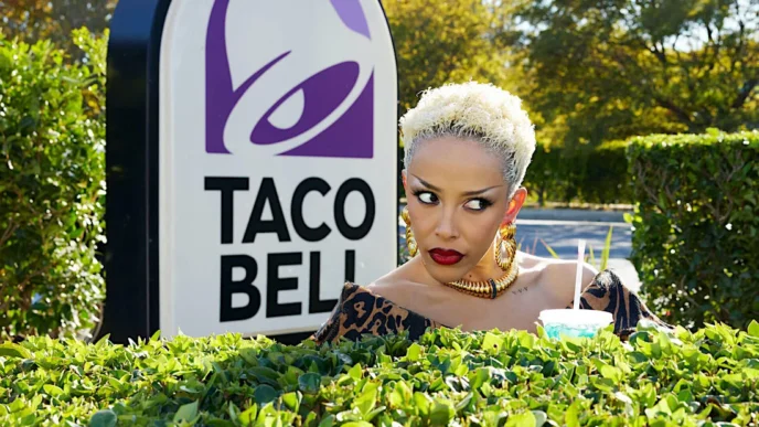 Mulher com bebida ao lado de placa Taco Bell.