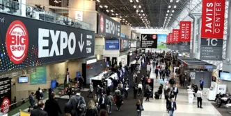 Pessoas visitando exposição em centro de convenções movimentado.