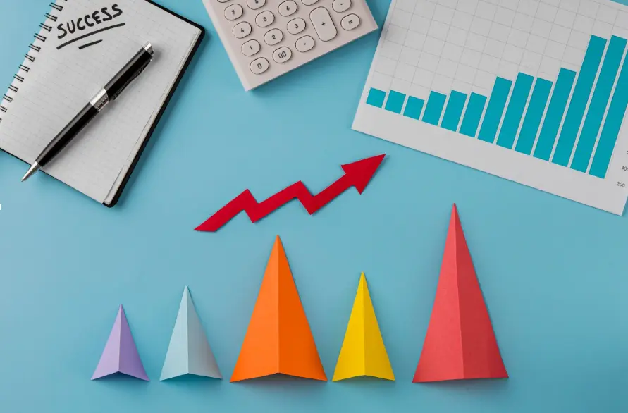 Gráfico de crescimento com pirâmides coloridas e caderno.