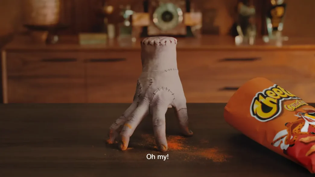 Mão decepada ao lado de Cheetos na mesa.