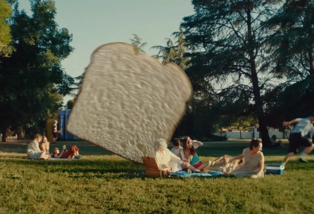Pessoas em piquenique assustadas com pão gigante.
