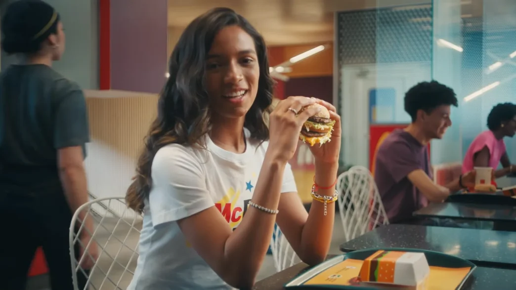 Pessoa segurando hambúrguer em lanchonete moderna.