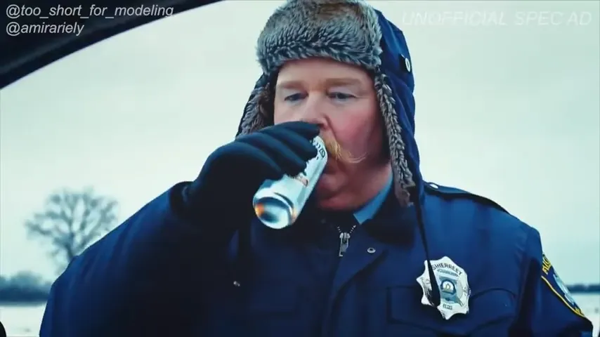 Policial bebendo algo em lata no frio.