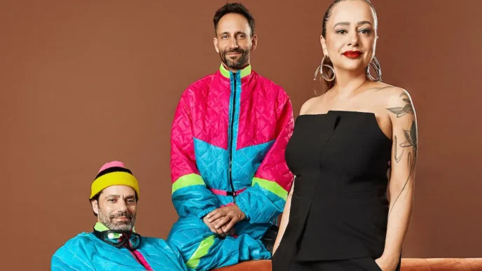 Três pessoas vestidas em roupas coloridas.