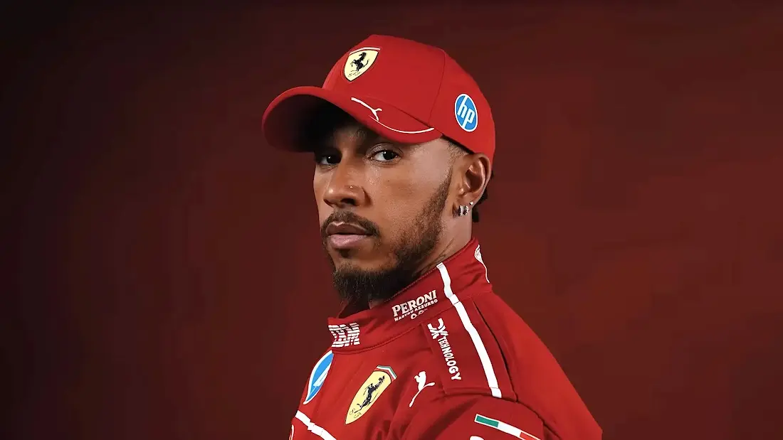 Piloto em uniforme vermelho da Ferrari.