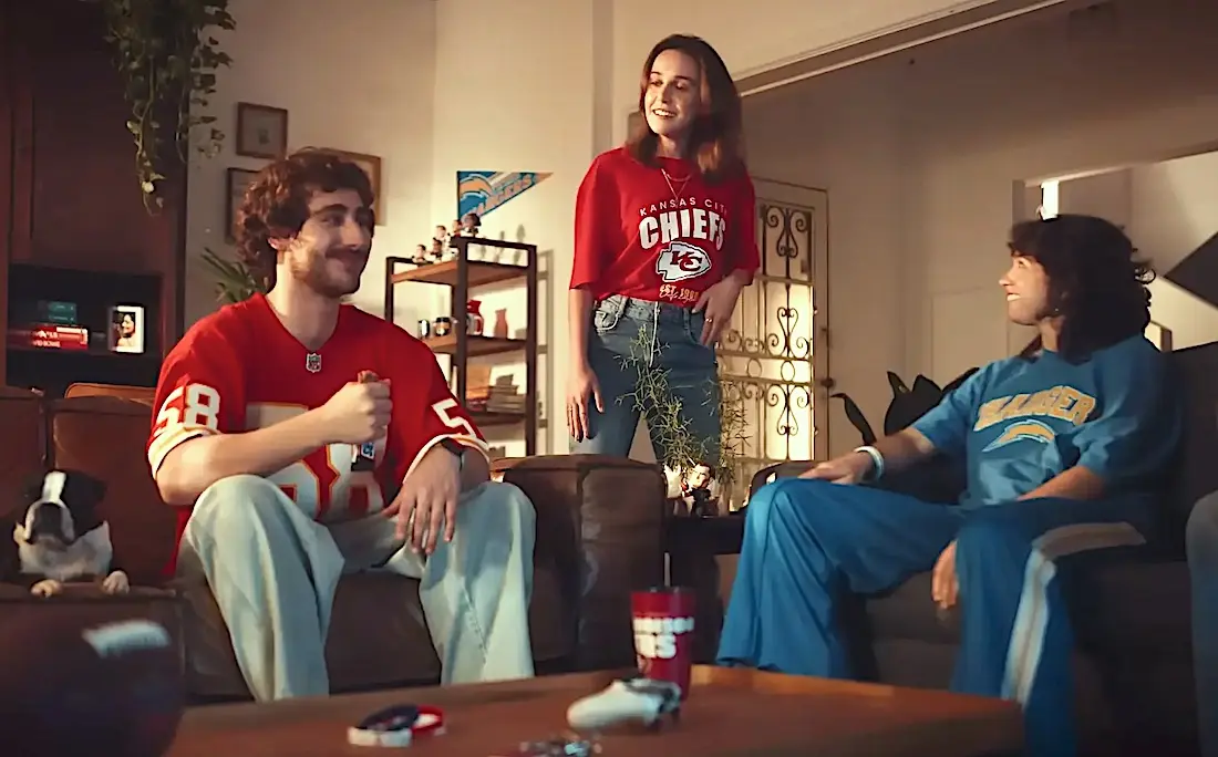 Amigos assistindo futebol americano na sala.