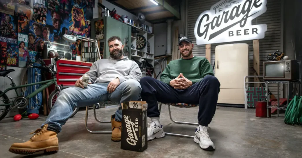 Homens sorrindo em garagem com cerveja Garage Beer.