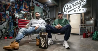Homens sorrindo em garagem com cerveja Garage Beer.