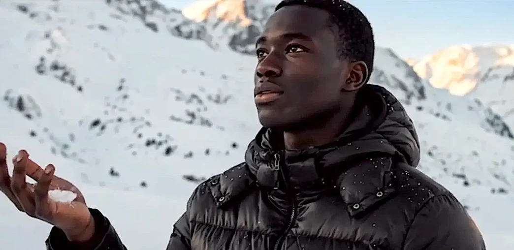 Pessoa segurando neve em montanha nevada.