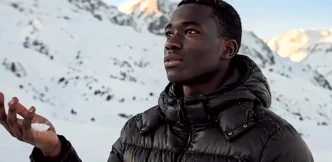 Pessoa segurando neve em montanha nevada.