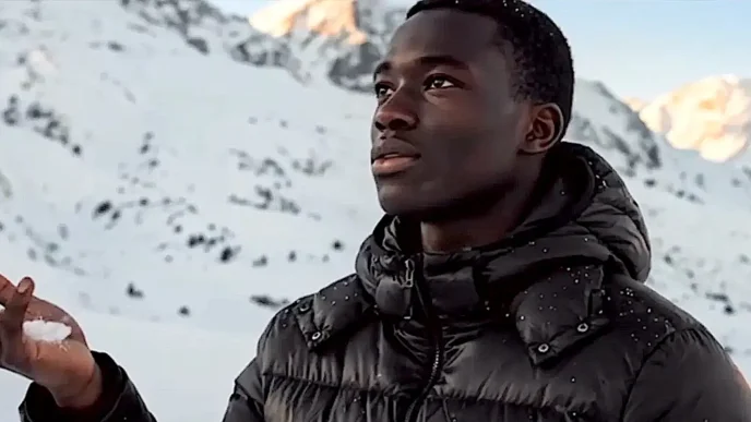 Pessoa segurando neve em montanha nevada.