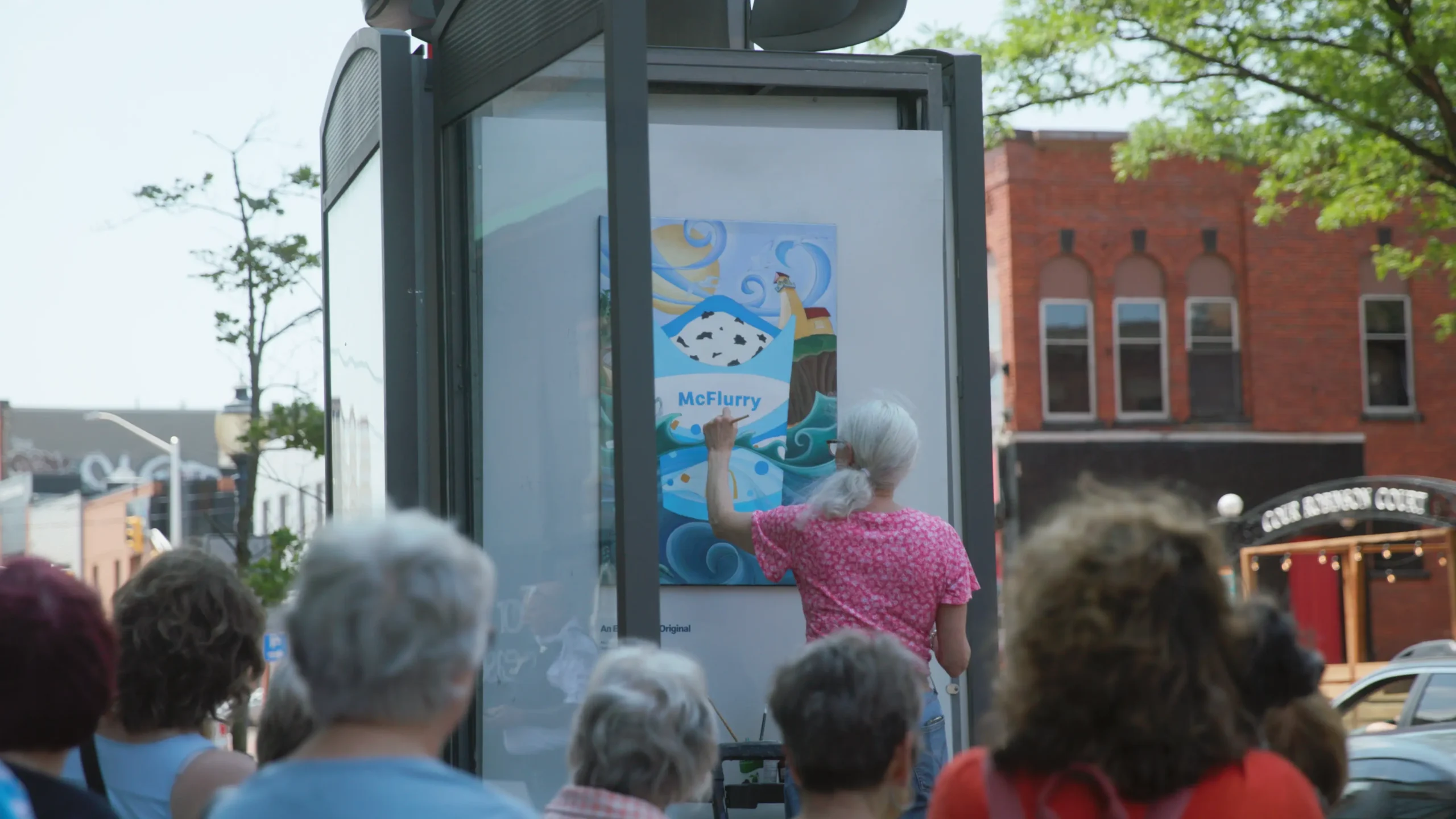 Pintura ao ar livre em rua movimentada.