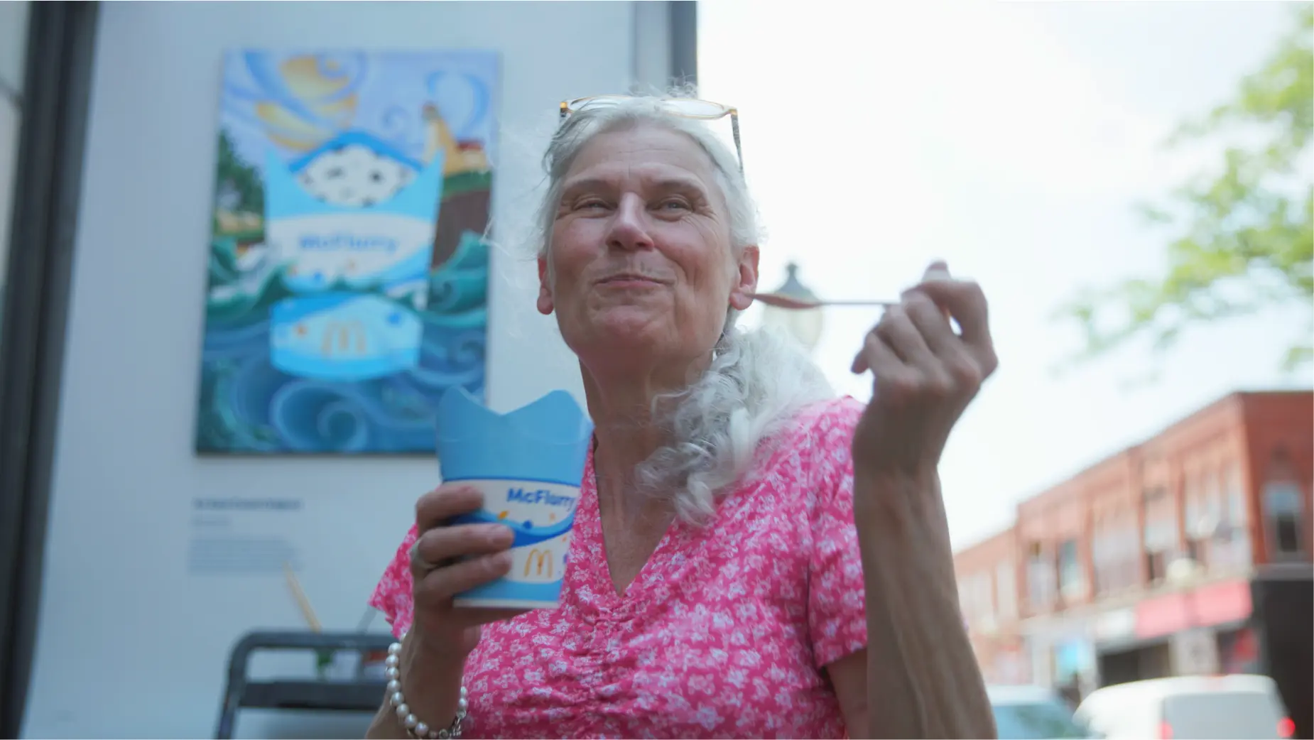 Pessoa apreciando sobremesa de sorvete ao ar livre.